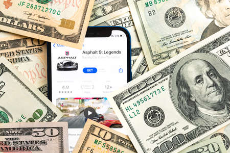 Asphalt 9 mobile game app. Money background. Concept, company making money with popular mobile phone gamesのeditorial素材