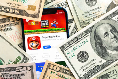 Super Mario Run mobile game app. Money background. Concept, company making money with popular mobile phone gamesのeditorial素材