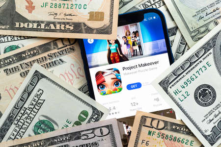 Project Makeover mobile game app. Money background. Concept, company making money with popular mobile phone gamesのeditorial素材