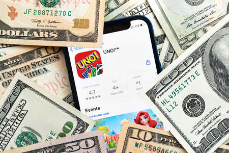 Uno mobile game app. Money background. Concept, company making money with popular mobile phone gamesのeditorial素材