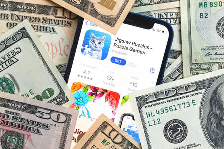 Jigsaw Puzzles mobile game app. Money background. Concept, company making money with popular mobile phone gamesのeditorial素材