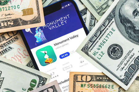Monument Valley mobile game app. Money background. Concept, company making money with popular mobile phone gamesのeditorial素材