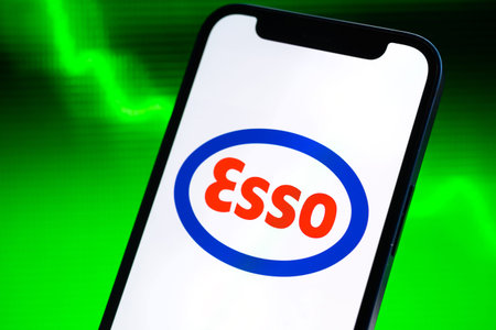 Poltava, Ukraine - May 9, 2022: Index of Esso oil prices, logo close-up. Green stock market graph...