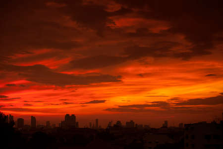 Sunset over modern office buildings in business district center of Bangkok. Skyline view of cityscape with sunlight and flare . Construction business concept. Abstract orange skyの写真素材
