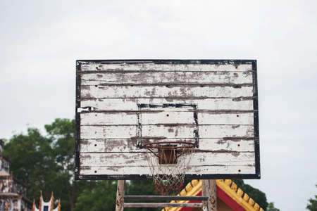 Old basketball backboard and basket. Deserted basketball backboard on a background of trees.の写真素材