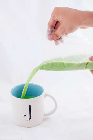 Men hand plastic bag milk Green tea Pour milk into glass.の写真素材