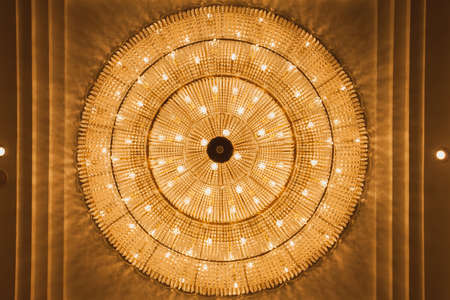 image  crystal chandelier whith Spherical.Crystal made chandeliers light orange.On the ceiling .Select focus pointの写真素材