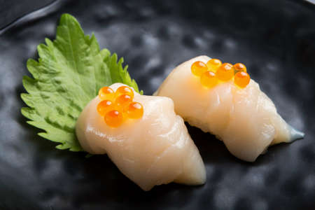 Creative Japanese food.Scallop Sushi on oba  leaf.Salmon roe is topの写真素材