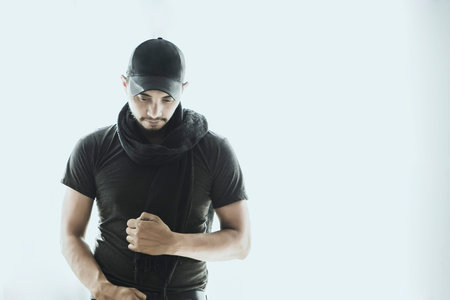 Attractive man standing, staring at the ground,shooting in the studio with space for letters