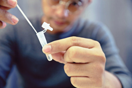 Man uses cotton swab to test for  Insert a reagent bottle to look for what is believed to be a virus.の写真素材
