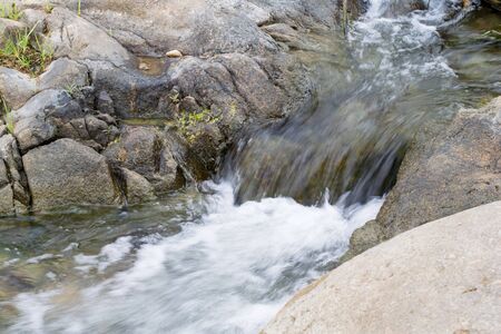 Waterfall was coming down from the mountain cliff.の写真素材