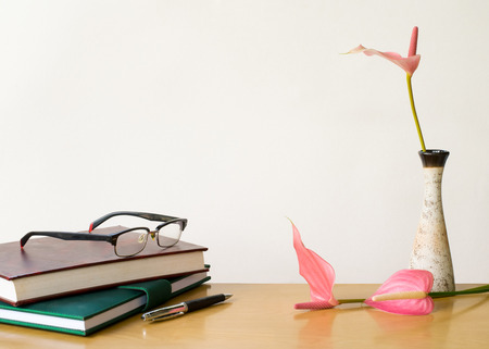 Composition on desk with books and flowers on white backgroundの写真素材
