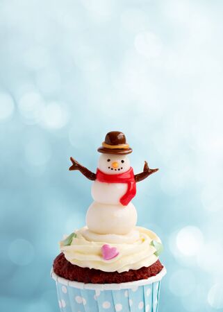 Cute snowman cupcake on blue backgroundの写真素材