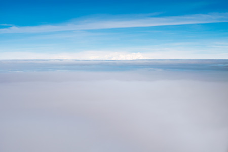 Blue sky and clouds. view from the window of an airplane flying in the cloudsの写真素材