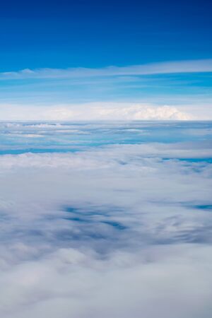 Blue sky and clouds. view from the window of an airplane flying in the cloudsの写真素材