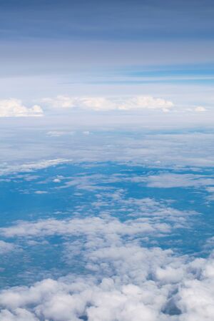 Blue sky and clouds. view from the window of an airplane flying in the cloudsの写真素材