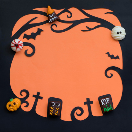 Top view ; Ghost fancy chocolates on Halloween paper cut backgroundの写真素材