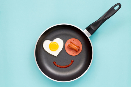 Top view ; Smile breakfast in a pan on cyan backgroundの写真素材