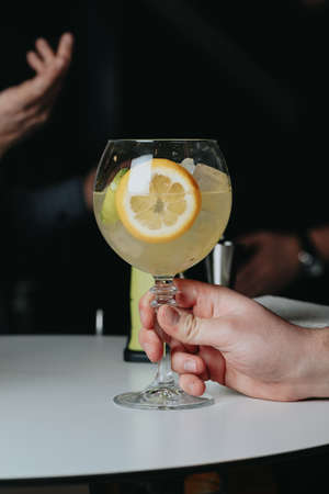 Cocktails with champagne in wine glasses on the bar table in the pub or restaurant with the bartender.の写真素材