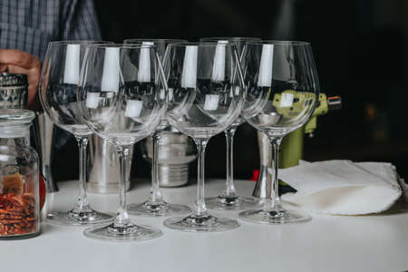 Cocktails with champagne in wine glasses on the bar table in the pub or restaurant with the bartender.の写真素材