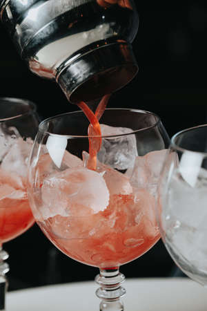 Cocktails with champagne in wine glasses on the bar table in the pub or restaurant with the bartender.の写真素材