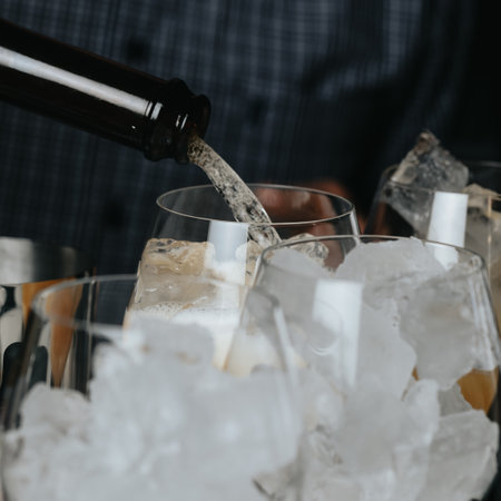 Cocktails with champagne in wine glasses on the bar table in the pub or restaurant with the bartender.の写真素材