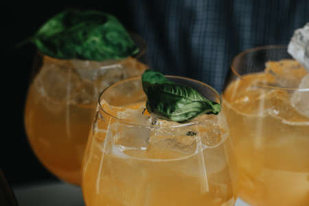 Cocktails with champagne in wine glasses on the bar table in the pub or restaurant with the bartender.の写真素材