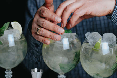Cocktails with champagne in wine glasses on the bar table in the pub or restaurant with the bartender.の写真素材