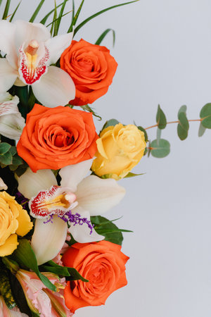 Ceramic vase with roses, cymbidium, alstroemeria and greenery.