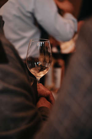 We celebrate success with a glass of red rose and white wine in hand at a special tasting with happy people.の写真素材