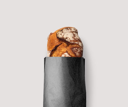 Fresh bread baked with seeds in a kraft paper bag natural white or blackの写真素材