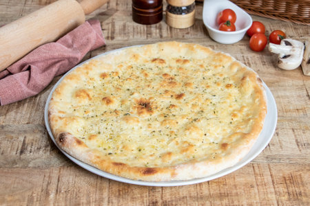 Traditional italian focaccia bread on a wooden table with ingredientsの写真素材