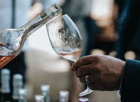 Close-up of a man's hand pouring white wine into a glassの写真素材