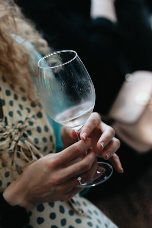 Close-up of a woman's hands holding a glass of wineの写真素材