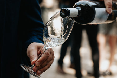 Close-up of a man's hand pouring champagne into a glassの写真素材