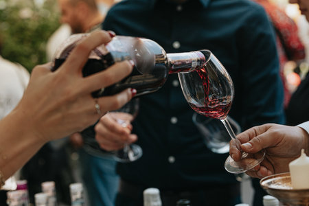 People clinking glasses with red wine at a wine tasting event.の写真素材