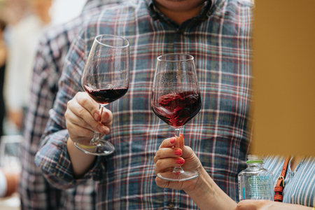 Close-up of two glasses of red wine in hands of man and womanの写真素材