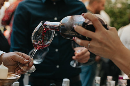 Close-up of a group of people clinking glasses with red wineの写真素材