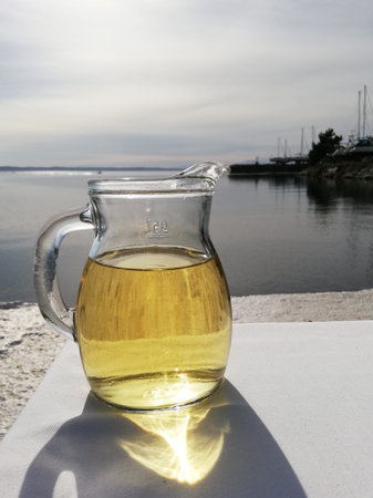 Jag with white wine on the table with sea and yacht view