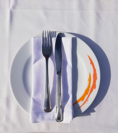 fork and knife on the napkin in the plate wich is on the table