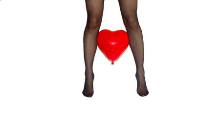 woman legs in black tights with red heart baloon between on white backgroundの写真素材
