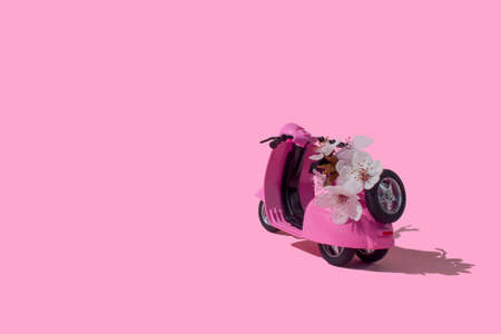 Pink retro toy car delivering bouquet of flowers box on pink background. February 14 card, Valentine's day. Flower delivery. 8 March, International Happy Women's Day. Mother's day.の写真素材