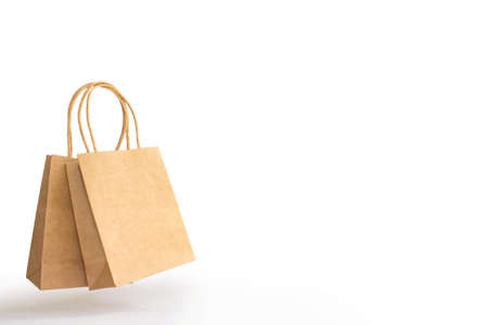 two brown paper shopping bags with hands and shadow isolated on white background. Levitation on white.の写真素材