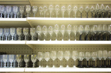 Many different gwinelasses for wine and shampagne on the shelves in store with place for prices.の写真素材