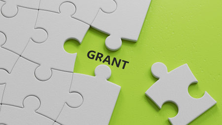 The white puzzle pieces with missing pieces with GRANT business word.close up of The white puzzle...