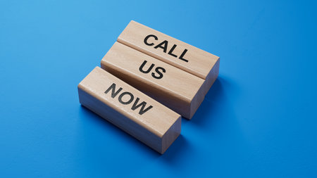 Call us now symbol. wooden blocks with words Call us now.Business and Call us now concept. Copy space.3D rendering on blue background.の写真素材