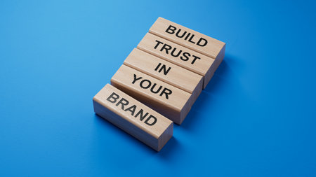 Wooden blocks with words Build trust in your brand. Business and Build trust in your brand concept. 3D rendering on blue background.の写真素材