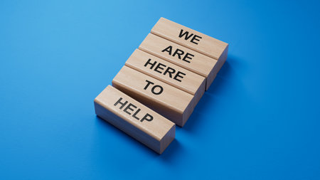 We are here to help symbol. Concept words we are here to help on wooden blocks.Business and we are here to help concept. Copy space.3D rendering on blue background.の写真素材