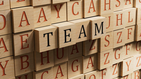 The hand puts a wooden blocks with the letter T from the word Team. The word is written on wooden...