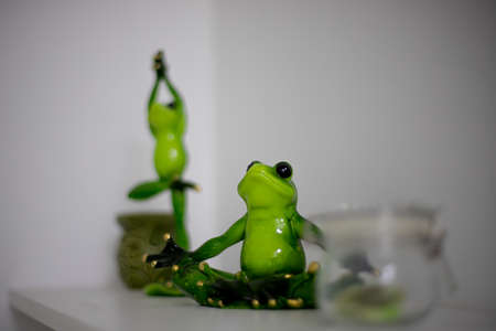 OMSK, RUSSIA, MAY 08, 2020: a statuette of a green frog stands on a white shelf.のeditorial素材
